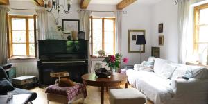 ein Wohnzimmer mit Sofa und Klavier in der Unterkunft Moniówka in Nowe Kawkowo