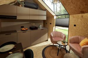 uma sala de estar com duas cadeiras cor-de-rosa e uma televisão em KampinaStaete Diamond Suite em Oisterwijk