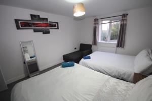a hotel room with two beds and a window at Holden Court Apartments -Apt 4 in West Drayton