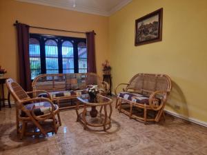 a living room with wicker chairs and a table at Casa Balfré in Mérida