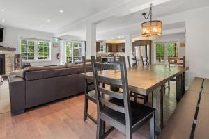 a dining room and living room with a table and a couch at Scandia Retreat with Hot Tub, Sauna and Fire Pit in Blue Mountains