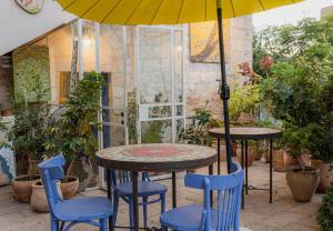 a patio with two tables and two chairs and an umbrella at Khalil lane in the Village in Mi‘ilyā