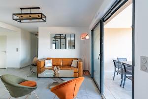 een woonkamer met een bank, stoelen en een tafel bij Les Rivages De Stagnola in Pietrosella +11 foto's