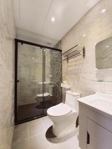 a bathroom with a toilet and a shower and a sink at 站前夥伴旅宿 in Hualien City