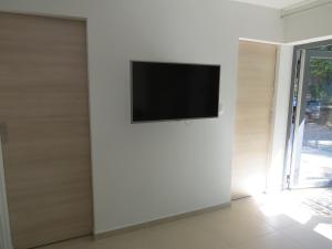 TV de pantalla plana en la pared de una habitación en Camping Mia Bungalow & Mobile Home, en Biograd na Moru