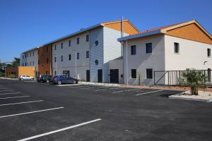 a parking lot in front of a building at ibis styles Villeneuve Sur Lot in Villeneuve-sur-Lot