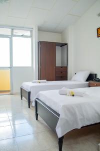 Zimmer mit 2 Betten und einem Schrank in der Unterkunft Hotel Centauros del Llano in Villavicencio