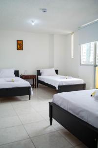 Habitación con 3 camas en una habitación en Hotel Centauros del Llano, en Villavicencio