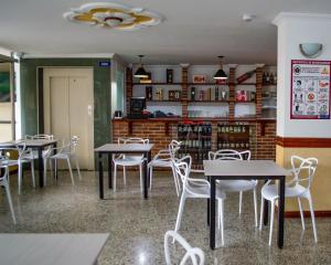 a dining room with tables and white chairs at Hotel Centauros del Llano in Villavicencio