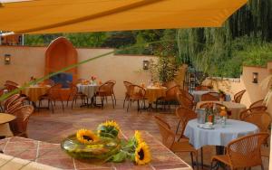 a restaurant with tables and chairs and a yellow umbrella at Fischerstüberl Attel in Wasserburg am Inn
