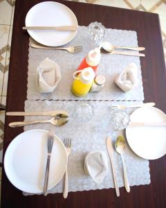 a table with white plates and silverware on it at Hopewell Guest House in Nyeri