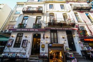 un grand bâtiment blanc avec des boîtes de fleurs sur les balcons dans l'établissement Sarnıç Butik Otel, à Istanbul