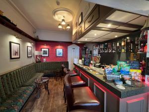 un bar avec des sièges verts dans un restaurant dans l'établissement Raffles Hotel, à Blackpool