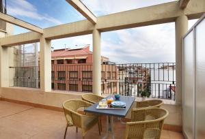 un patio con tavolo e sedie su un balcone di Apartamentos Calvet a Barcellona