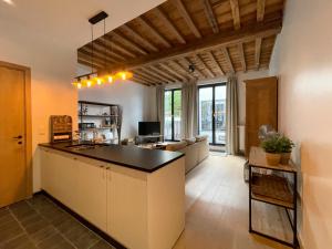 uma cozinha e sala de estar com um balcão e um sofá em Begijnhof 102 em Gent