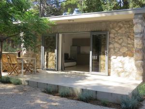 una puerta corredera de cristal de una casa de piedra con patio en Camping Mia Bungalow & Mobile Home, en Biograd na Moru