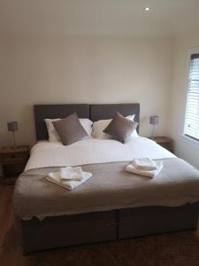 a bedroom with a large bed with two towels on it at Arrochoile Cottage in Glasgow