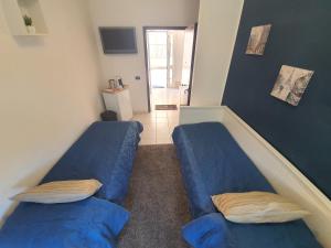 2 camas azules en una habitación con pasillo en Guest House Brezza Marina, en Fiumicino