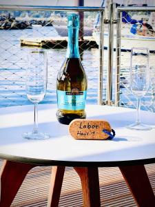 拉博埃的住宿－Floating Home Nr 1，一张桌子上放着一瓶葡萄酒,放上两杯