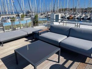 a deck with couches and tables on a boat at Floating Home Nr 1 in Laboe