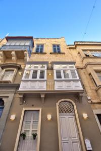 un edificio alto con ventanas y una puerta en Chateau La Vallette - St. Elmo Suite, en La Valeta