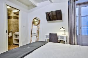 Dormitorio con cama, escritorio y TV en Chateau La Vallette - St. Elmo Suite, en La Valeta
