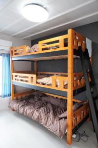 two bunk beds in a room with a bed at ゲストハウス庵（いおり）大阪 