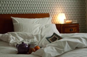 Una cama con una tetera y fruta. en Casatitta Bed & Breakfast, en Milán
