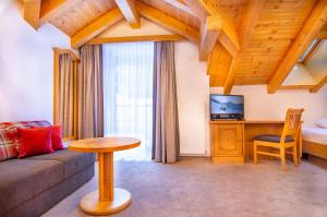 ein Wohnzimmer mit einem Sofa und einem Tisch in der Unterkunft Hotel Garni Waldschlössl in Ischgl