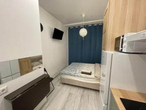 モスクワにあるАпартаменты на Хромова 3のベッド1台、冷蔵庫が備わる小さな客室です。
