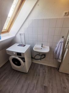 a small bathroom with a sink and a washing machine at Möblierte Wohnung im Herzen Ottersbergs für Monteure und geschäftlich Reisende in Ottersberg
