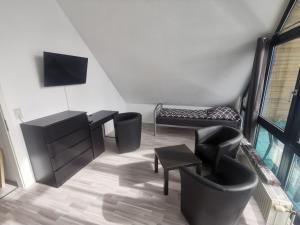 sala de estar con sillas negras y TV en Möblierte Wohnung im Herzen Ottersbergs für Monteure und geschäftlich Reisende, en Ottersberg