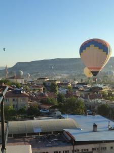 een heteluchtballon die over een stad vliegt bij Balloon View Hotel in Goreme