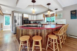 een keuken met een houten eiland met barkrukken bij 13 Oak Ridge Road in Madison
