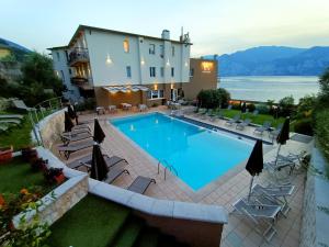 a large swimming pool in front of a building at Hotel Antonella in Malcesine