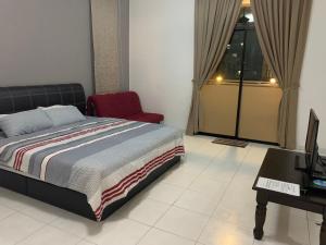 1 dormitorio con cama, escritorio y silla en Woon Homestay, en Balik Pulau