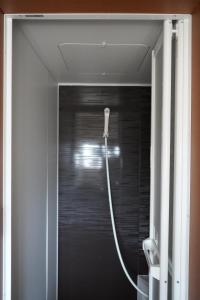 a shower in a bathroom with a hose at ゲストハウス庵（いおり）大阪 