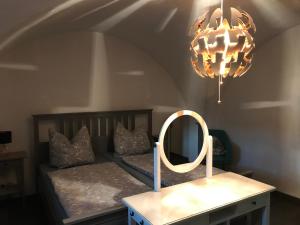 een slaapkamer met een bed met een spiegel en een kroonluchter bij Ferienwohnung Kieslich in Habrachćicy