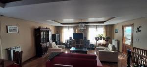 SHOTEL Calafate في إل كالافاتي: غرفة معيشة مع أريكة وكراسي وتلفزيون