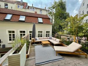 eine Terrasse mit einem Sofa und Stühlen auf einer Terrasse in der Unterkunft pestahome in Hannover