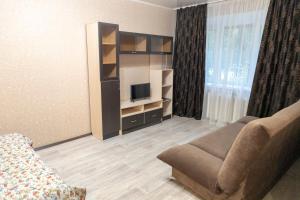 salon z kanapą i telewizorem w obiekcie Apartment Ural on Evteeva 5 w mieście Czelabińsk