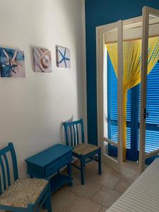een kamer met 2 stoelen, een tafel en een raam bij casa patrizia in Villanova di Ostuni