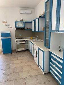 una cucina con armadi blu, lavandino e lavastoviglie di casa patrizia a Villanova