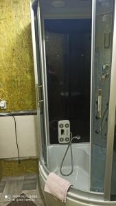 a bathroom with a shower with a plug in it at Бюджетне житло in Kunovka