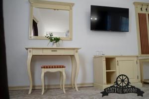 a dressing table with a stool and a mirror at Curtea Veche in Hunedoara