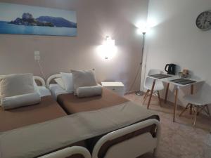 una camera con due letti, un tavolo e una lampada di Villa Soula Kaliva a Kefalos