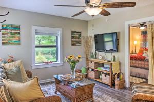 a living room with a couch and a tv at Shaw Creek Cottage with Fire Pit and Forest Views in Hendersonville