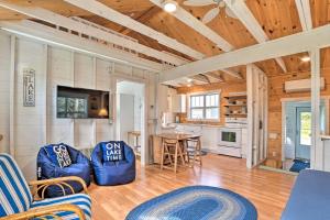 een woonkamer met blauwe stoelen en een keuken bij Cozy Cedarville Cottage - Walk to Lake Huron! in Cedarville