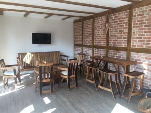 a room with wooden tables and chairs and a tv at Kämmererhof - Inselperle in Fehmarn