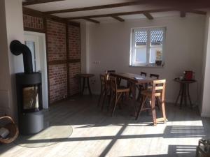 a room with a fireplace and a table and chairs at Kämmererhof - Inselperle in Fehmarn